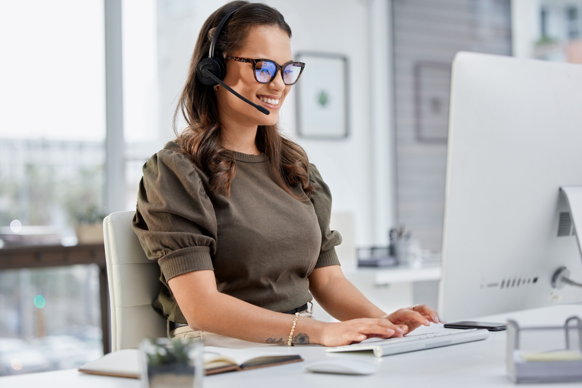 Cropped shot of an attractive young female call center agent working at her desk in the office